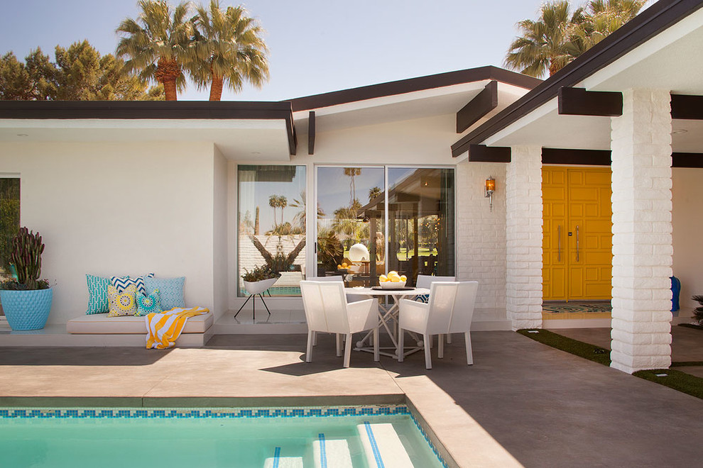 Inspiration for a midcentury patio in Los Angeles with a roof extension.