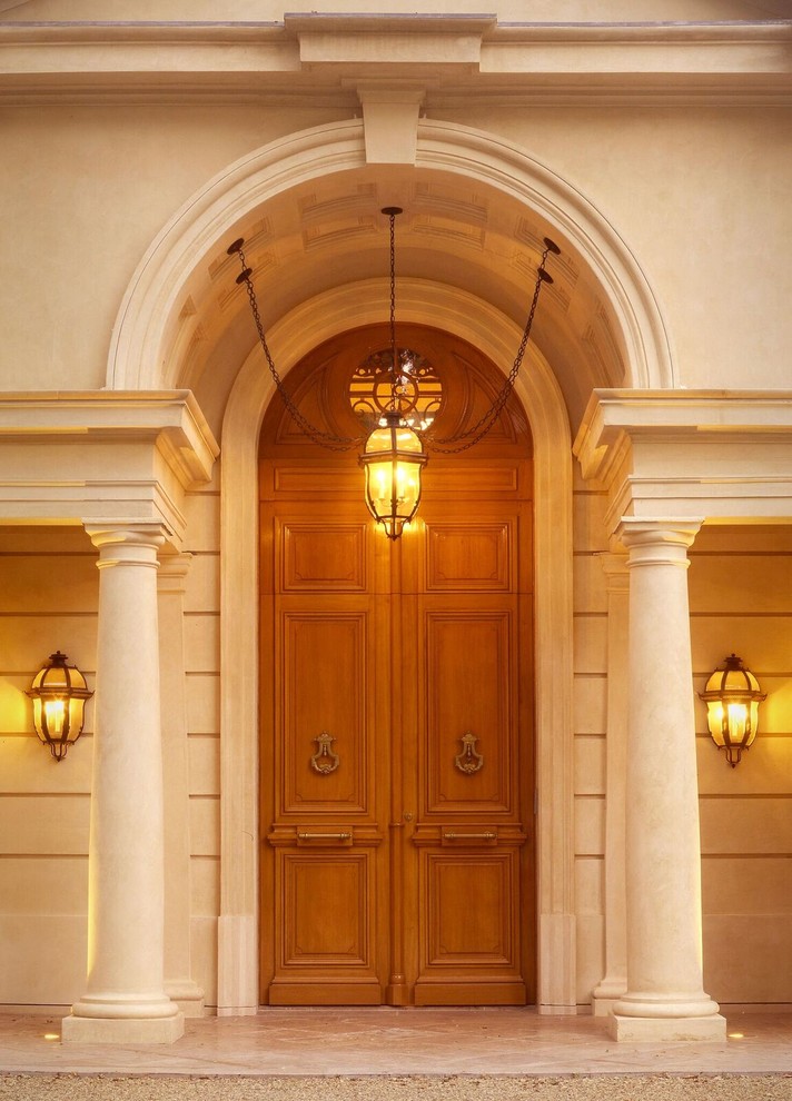 Photo of an expansive entryway with beige walls, ceramic floors, a double front door, a light wood front door and beige floor.