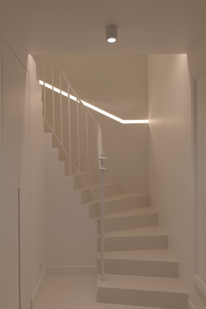 Exemple d'un escalier courbe tendance en béton de taille moyenne avec des contremarches en béton, un garde-corps en métal et éclairage.