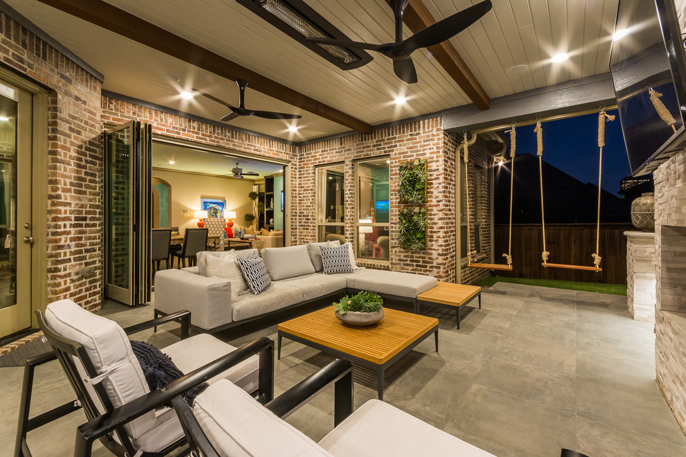 This is an example of an expansive transitional backyard patio in Dallas with tile and a roof extension.