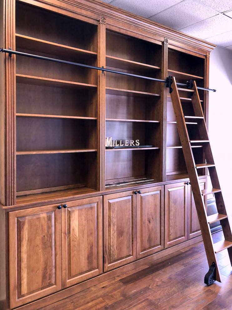 Idee per uno studio chic di medie dimensioni con libreria e pavimento in legno massello medio