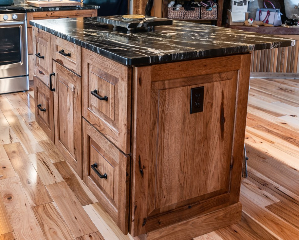 Kitchen - rustic l-shaped medium tone wood floor kitchen idea in Boston with an undermount sink, raised-panel cabinets, medium tone wood cabinets, granite countertops, gray backsplash, stainless steel appliances, an island and black countertops