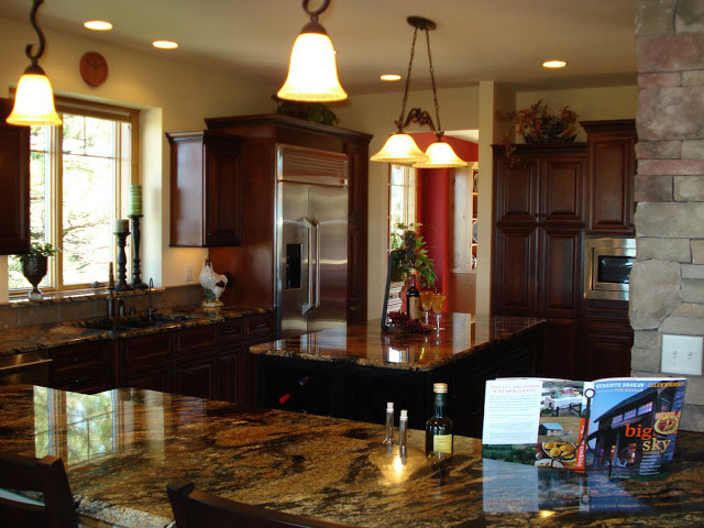 Example of a large mountain style u-shaped medium tone wood floor open concept kitchen design with beaded inset cabinets, dark wood cabinets, granite countertops, beige backsplash, stainless steel appliances and an island