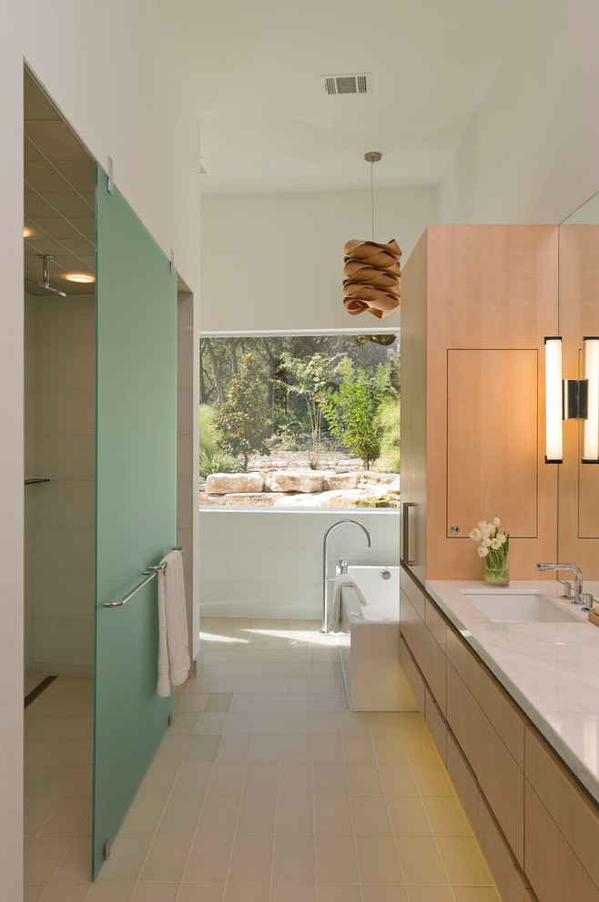 This is an example of a large contemporary master bathroom in Austin with light wood cabinets, an alcove tub, flat-panel cabinets, an alcove shower, white walls, an undermount sink, beige floor and an open shower.