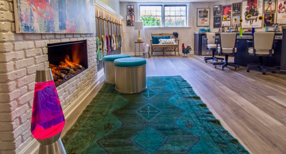 Photo of a large eclectic walk-out basement in Other with grey walls, vinyl floors, a standard fireplace, a brick fireplace surround and grey floor.