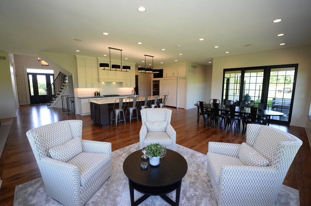 Open concept kitchen - large transitional single-wall medium tone wood floor open concept kitchen idea with an undermount sink, recessed-panel cabinets, white cabinets, granite countertops, white backsplash, stainless steel appliances and an island