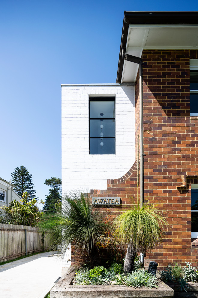 Réalisation d'une façade de maison blanche minimaliste en brique de taille moyenne et à un étage.