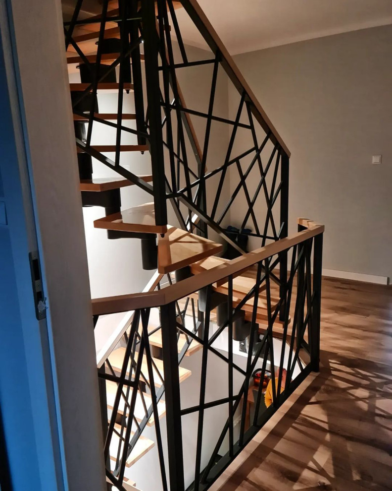 Medium sized industrial wood spiral metal railing staircase in Moscow with wood risers.