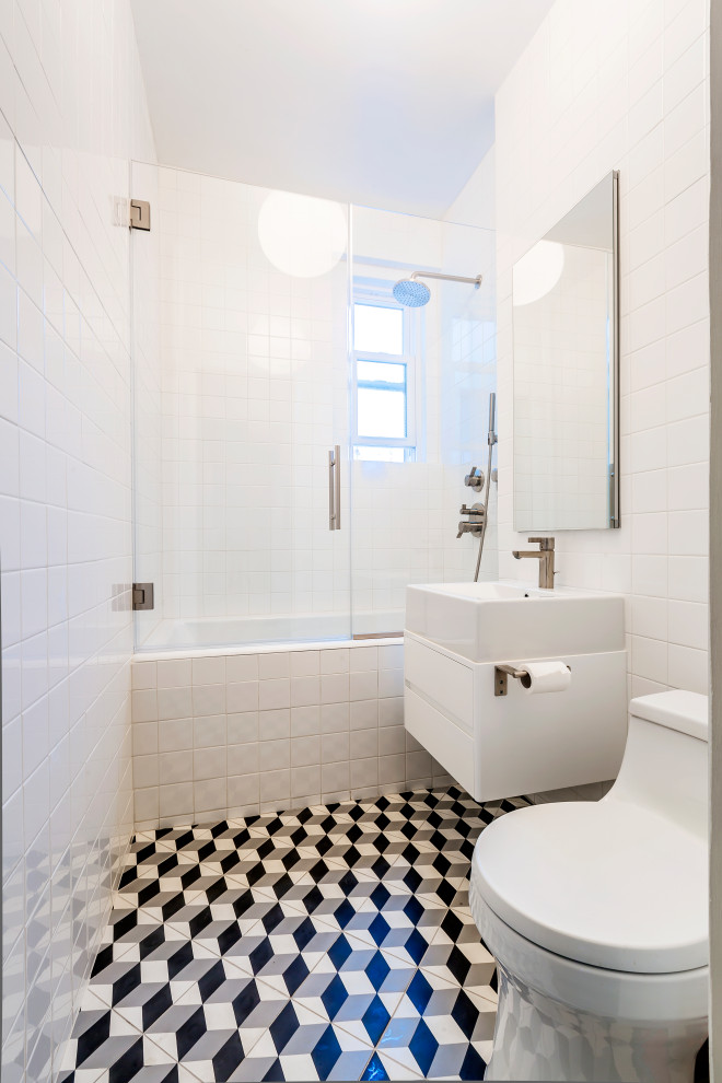 На фото: детская ванная комната среднего размера в современном стиле с плоскими фасадами, угловой ванной, душем в нише, унитазом-моноблоком, белой плиткой, керамической плиткой, белыми стенами, полом из керамической плитки, подвесной раковиной, мраморной столешницей, разноцветным полом, душем с распашными дверями, белой столешницей, тумбой под одну раковину, подвесной тумбой, потолком с обоями, панелями на части стены и белыми фасадами с