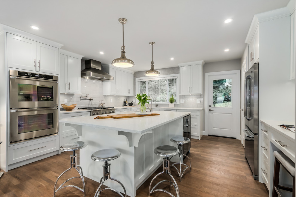Eat-in kitchen - large transitional u-shaped medium tone wood floor eat-in kitchen idea in Vancouver with a double-bowl sink, shaker cabinets, white cabinets, quartz countertops, gray backsplash, ceramic backsplash, stainless steel appliances and an island