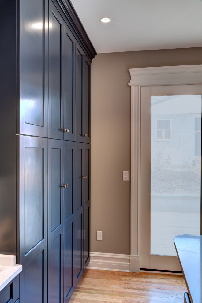 Inspiration for a mid-sized transitional l-shaped medium tone wood floor and brown floor enclosed kitchen remodel in DC Metro with a farmhouse sink, shaker cabinets, blue cabinets, quartz countertops, multicolored backsplash, ceramic backsplash, stainless steel appliances, an island and white countertops