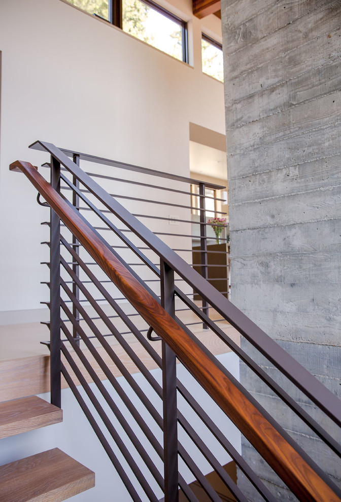 Photo of a large contemporary wood u-shaped staircase in San Francisco with open risers and metal railing.
