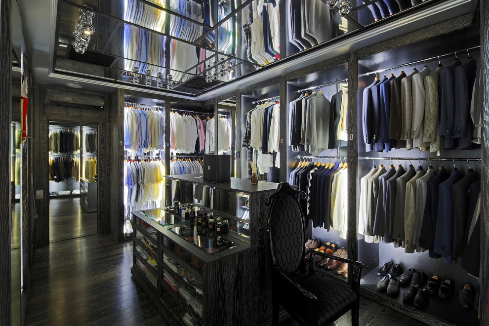 This is an example of an expansive contemporary men's dressing room in Moscow with open cabinets and dark hardwood floors.