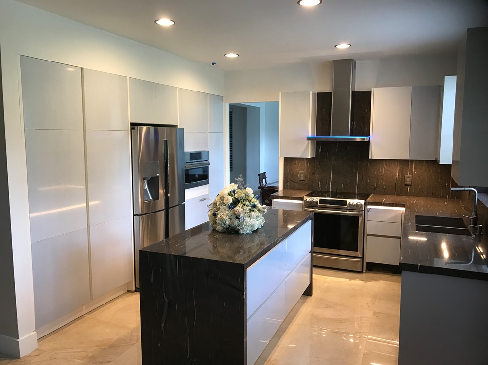 Design ideas for a mid-sized contemporary u-shaped kitchen in Miami with a double-bowl sink, flat-panel cabinets, white cabinets, black splashback, stone slab splashback, stainless steel appliances, with island, grey floor and black benchtop.