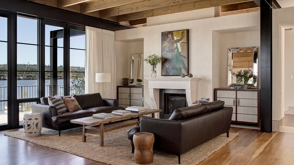 This is an example of a transitional living room in Seattle with white walls, medium hardwood floors and a standard fireplace.