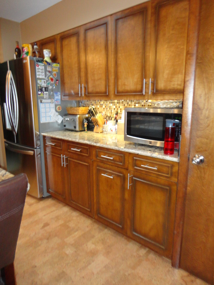 Example of a mid-sized l-shaped cork floor enclosed kitchen design with an undermount sink, quartzite countertops, multicolored backsplash, stainless steel appliances, beige walls and a peninsula