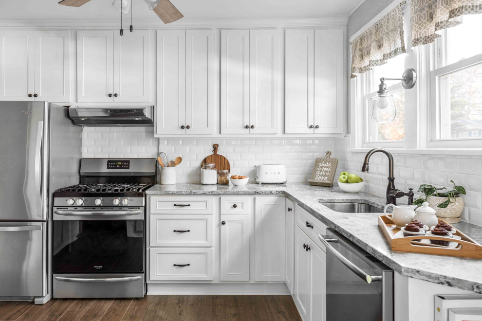 Idéer för mellanstora lantliga grått kök, med en enkel diskho, släta luckor, vita skåp, bänkskiva i kvartsit, vitt stänkskydd, stänkskydd i keramik, rostfria vitvaror, klinkergolv i porslin och brunt golv