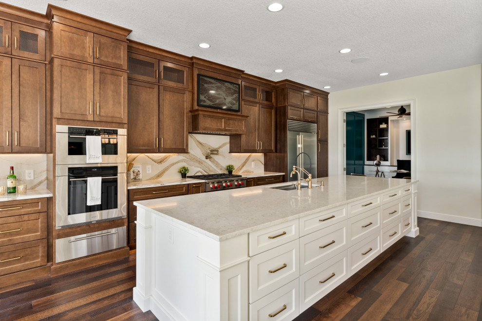 This is an example of an expansive transitional kitchen in Orlando with dark wood cabinets, quartz benchtops, beige splashback, stainless steel appliances, dark hardwood floors, with island and white benchtop.