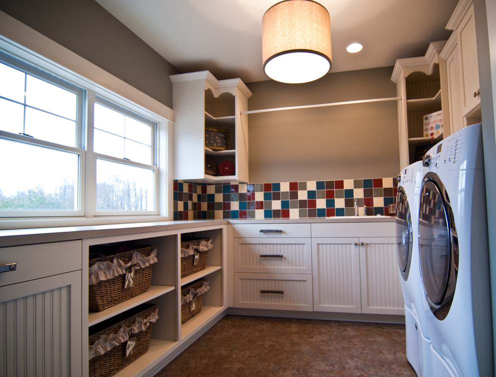 Mid-sized traditional u-shaped dedicated laundry room in Grand Rapids with a drop-in sink, beaded inset cabinets, white cabinets, laminate benchtops, multi-coloured splashback, ceramic splashback, beige walls, a side-by-side washer and dryer, beige floor and beige benchtop.