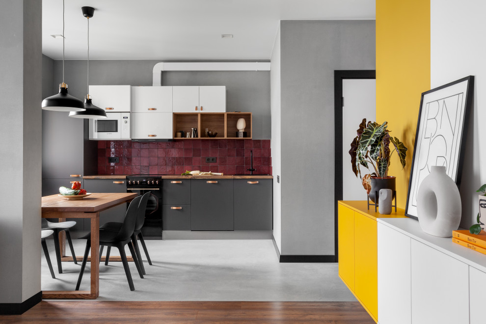Design ideas for a small contemporary eat-in kitchen in Other with flat-panel cabinets, grey cabinets, red splashback, ceramic splashback, concrete floors, no island, grey floor and brown benchtop.