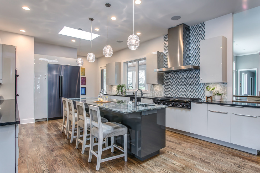 This is an example of a mid-sized contemporary galley eat-in kitchen in Denver with a double-bowl sink, flat-panel cabinets, blue cabinets, quartz benchtops, blue splashback, mosaic tile splashback, stainless steel appliances, medium hardwood floors, with island and blue benchtop.