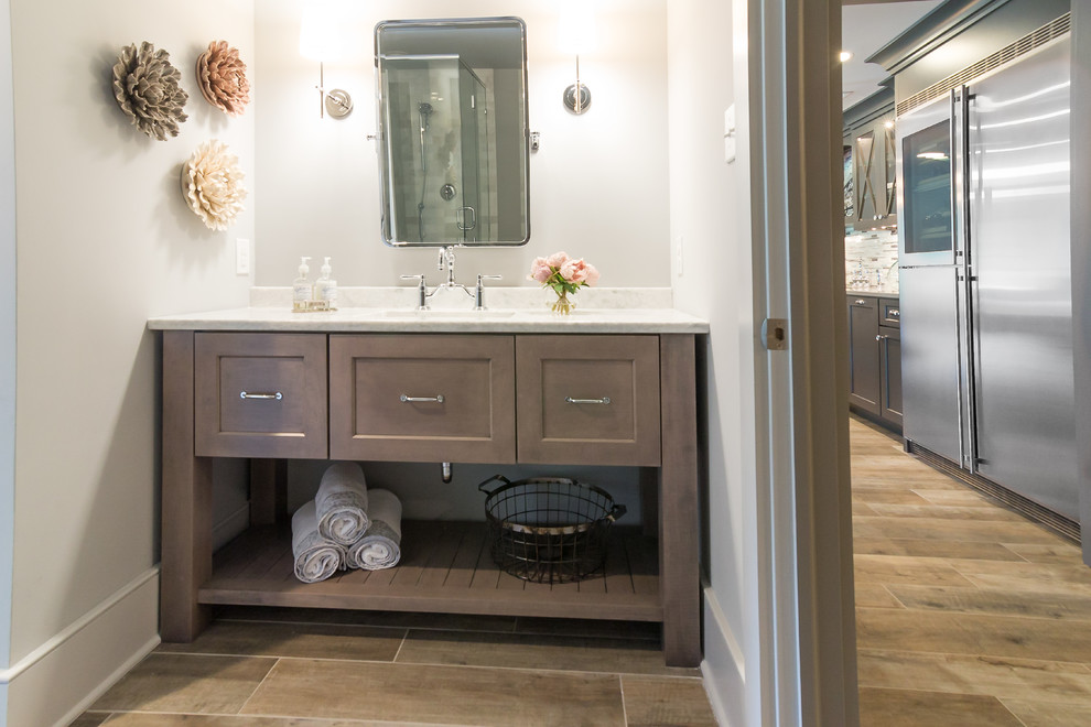 Small country powder room in Philadelphia with recessed-panel cabinets, beige cabinets, gray tile, ceramic floors, quartzite benchtops, beige floor, grey benchtops, white walls and an undermount sink.