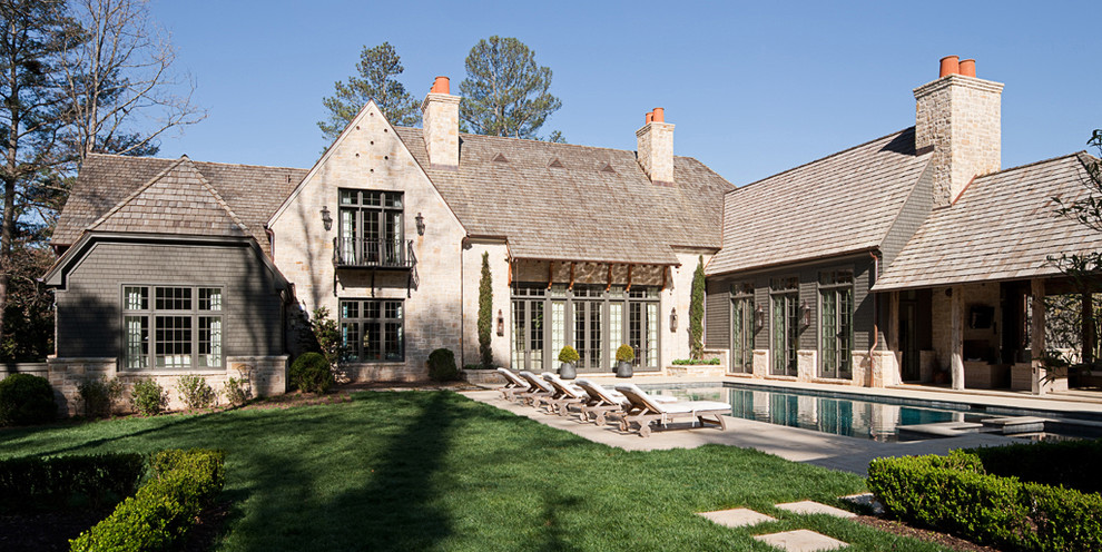 Photo of an expansive traditional two-storey grey exterior in Atlanta with stone veneer and a gable roof.