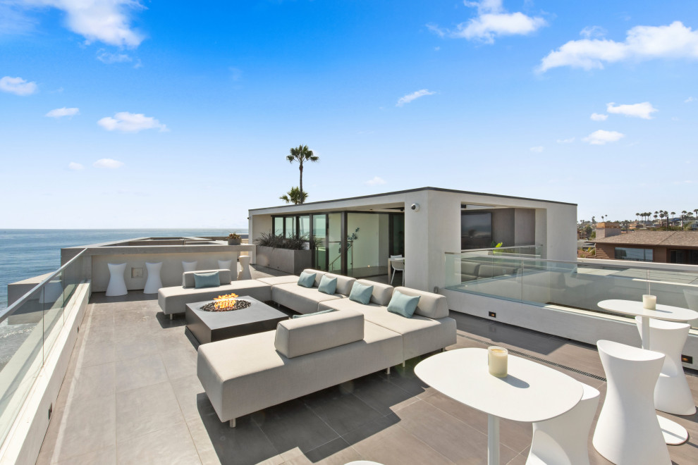 Large contemporary rooftop deck in San Diego with a fire feature and no cover.