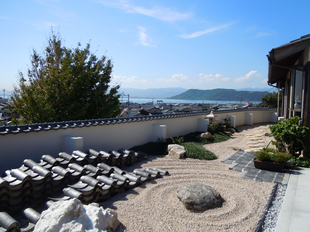 This is an example of an asian side yard full sun formal garden in Other with natural stone pavers.