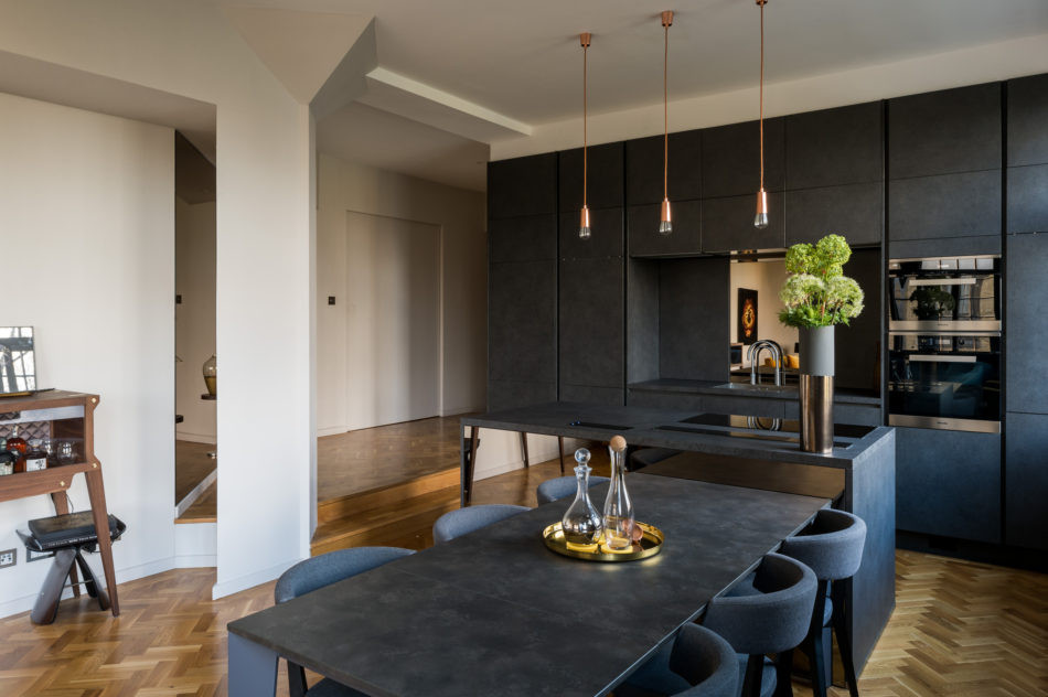 Große Industrial Wohnküche ohne Kamin mit schwarzer Wandfarbe, dunklem Holzboden und braunem Boden in London