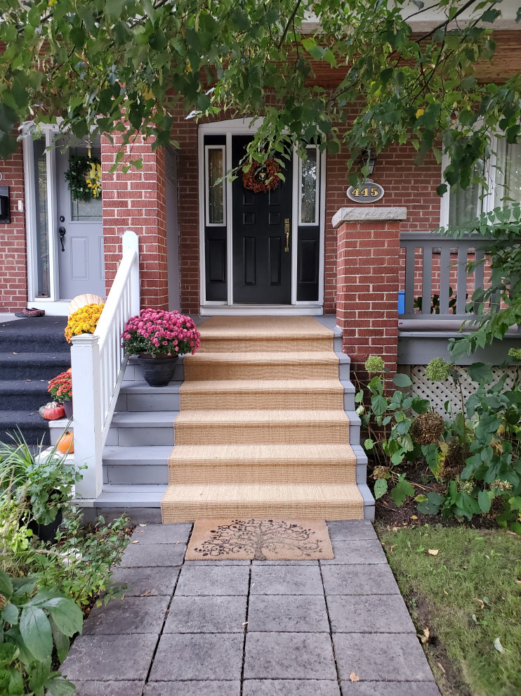 Design ideas for a beach style front yard verandah in Toronto with brick pavers.