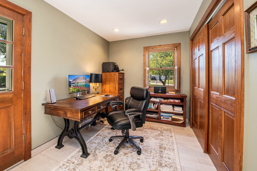 Inspiration for a medium sized classic study in Milwaukee with green walls, porcelain flooring, no fireplace, a freestanding desk and beige floors.