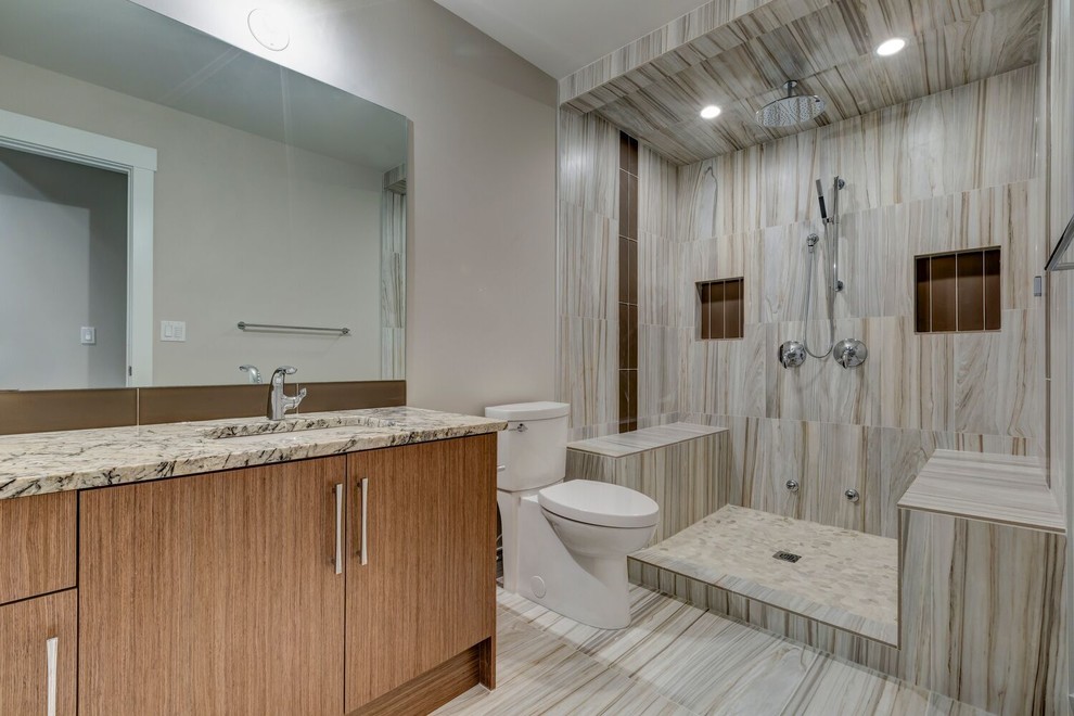 This is an example of a mid-sized transitional master bathroom in Calgary with flat-panel cabinets, an alcove shower, a two-piece toilet, brown tile, gray tile, grey walls, laminate floors, an undermount sink, granite benchtops, medium wood cabinets, ceramic tile, multi-coloured floor and an open shower.