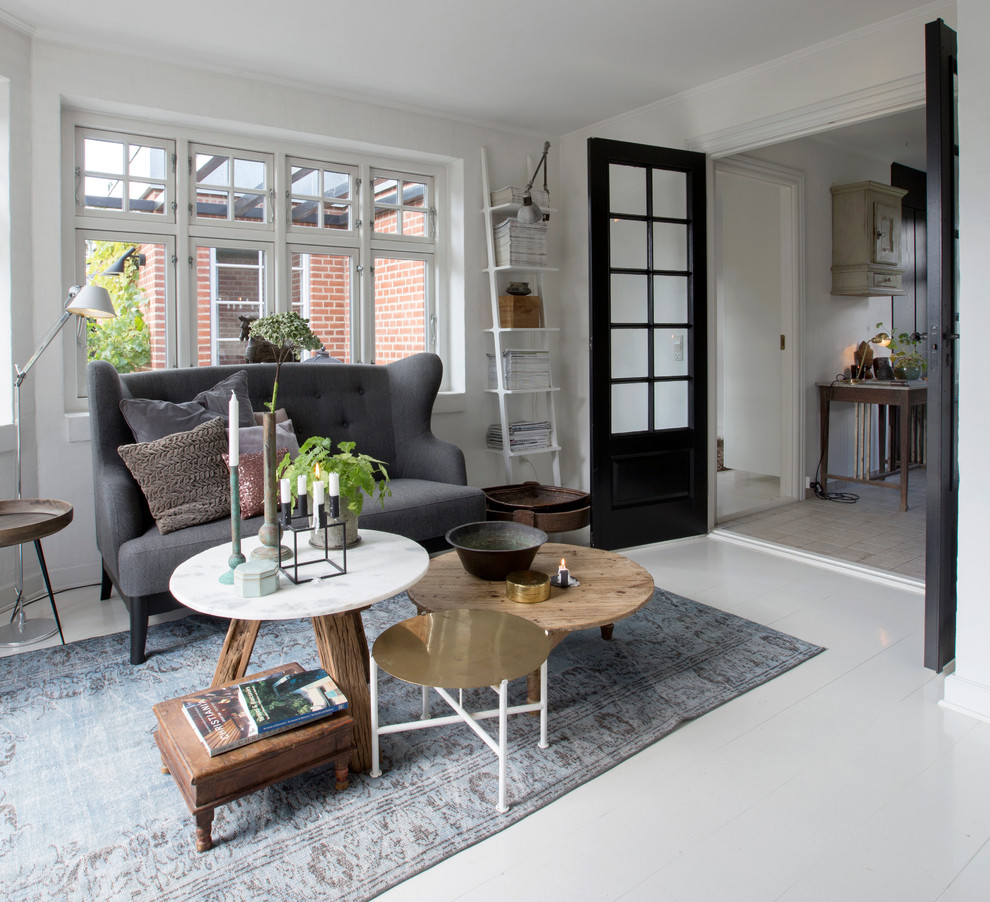 This is an example of a mid-sized scandinavian formal enclosed living room in Copenhagen with white walls, no fireplace, no tv and painted wood floors.