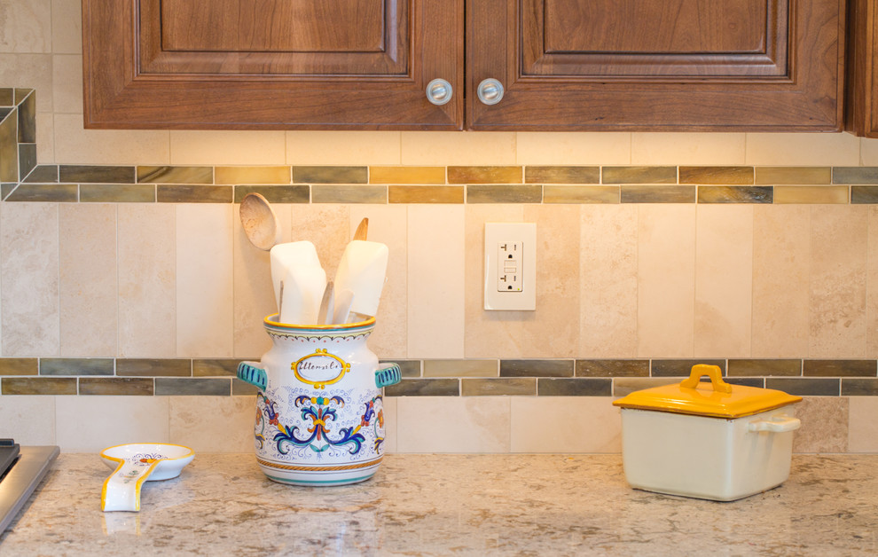 Inspiration for a large transitional l-shaped medium tone wood floor and brown floor eat-in kitchen remodel in Denver with a farmhouse sink, raised-panel cabinets, medium tone wood cabinets, granite countertops, beige backsplash, stone tile backsplash, stainless steel appliances and an island