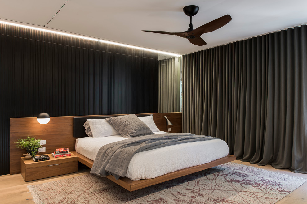 Inspiration for a mid-sized modern master bedroom in Sydney with white walls and light hardwood floors.