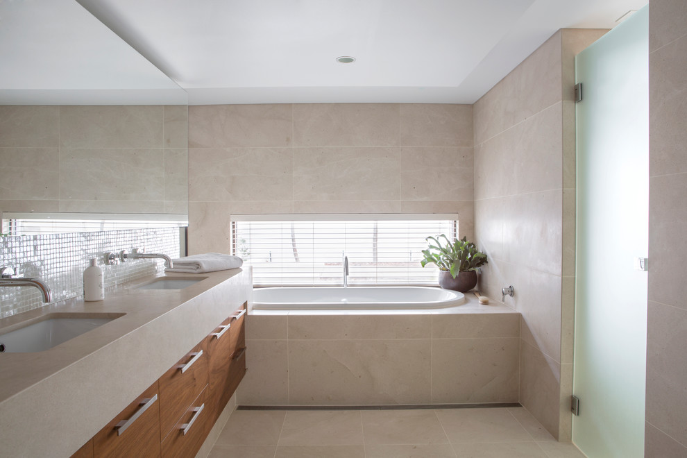 Design ideas for a large contemporary bathroom in Perth with flat-panel cabinets, medium wood cabinets, a drop-in tub, a corner shower, stone tile, an undermount sink and limestone benchtops.