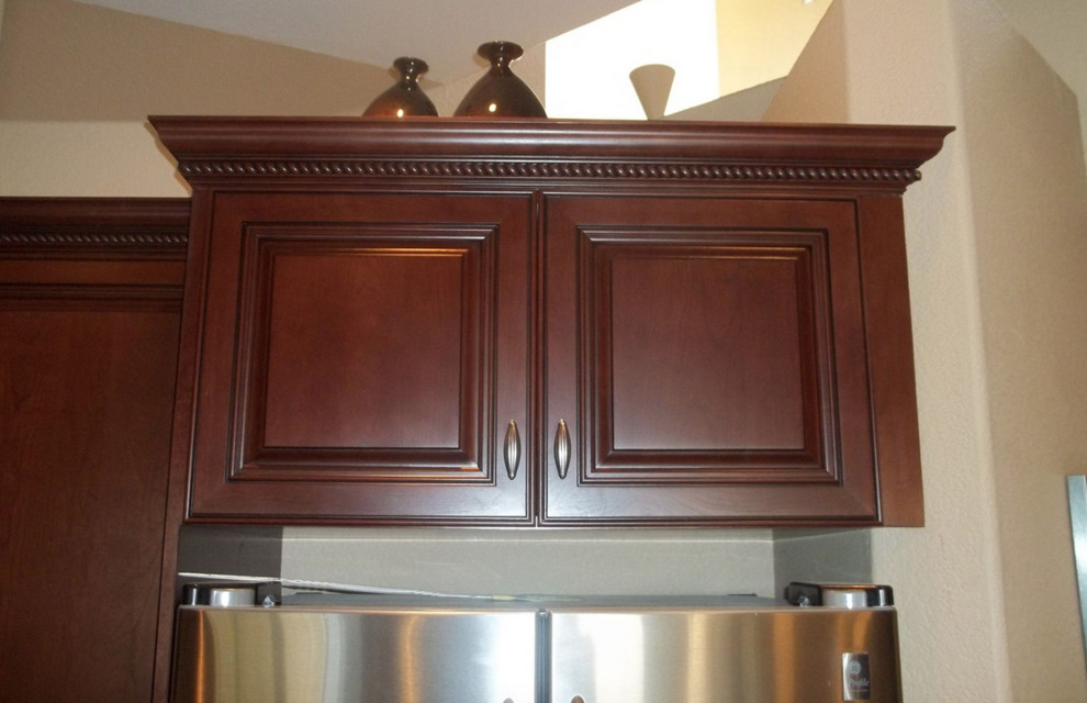 Kitchen - large traditional single-wall kitchen idea with dark wood cabinets, stainless steel appliances and an island