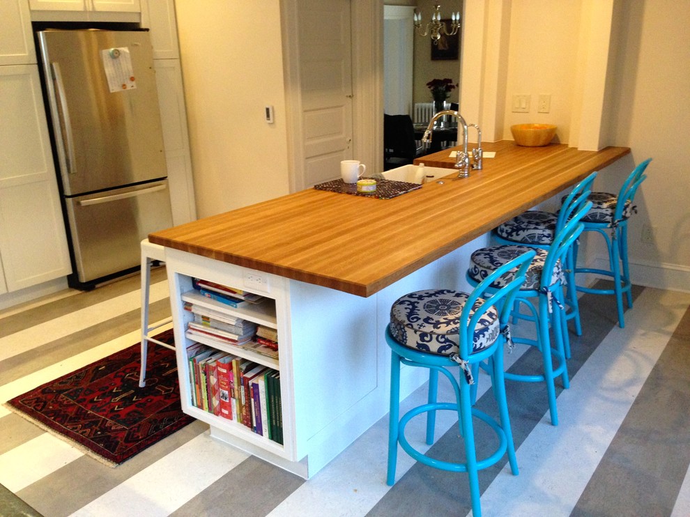 Inspiration for a large transitional cork floor home design remodel in Baltimore with a farmhouse sink, flat-panel cabinets, white cabinets, wood countertops, stainless steel appliances and a peninsula