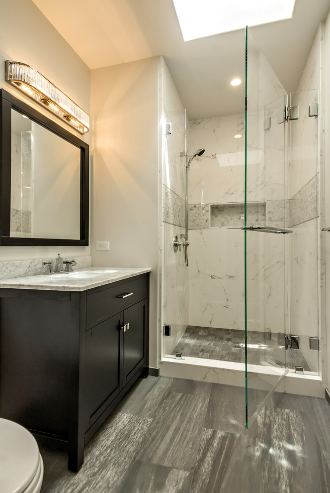 Design ideas for a mid-sized transitional 3/4 bathroom in San Francisco with shaker cabinets, brown cabinets, an alcove shower, a one-piece toilet, white tile, porcelain tile, grey walls, porcelain floors, an undermount sink, marble benchtops, grey floor and grey benchtops.