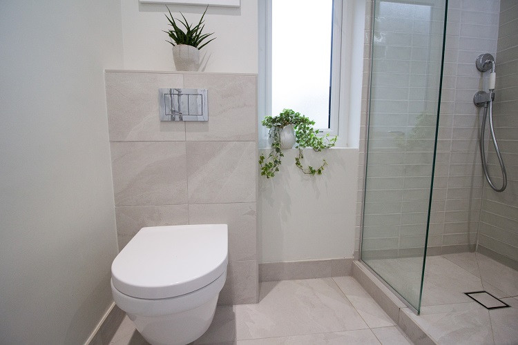 Inspiration for a medium sized contemporary bathroom in Other with shaker cabinets, green cabinets, a walk-in shower, a wall mounted toilet, white tiles, slate tiles, white walls, slate flooring, a built-in sink, white floors, an open shower, white worktops, feature lighting, a single sink and a built in vanity unit.