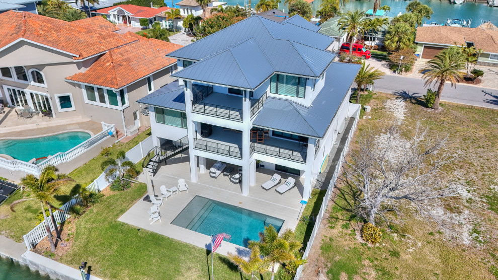 Inspiration for an expansive and multi-coloured modern detached house in Tampa with three floors, a pitched roof, a shingle roof and a blue roof.