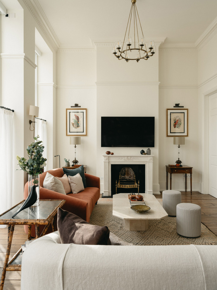 Inspiration for a traditional living room in London with white walls, medium hardwood flooring, a standard fireplace, a wall mounted tv and brown floors.