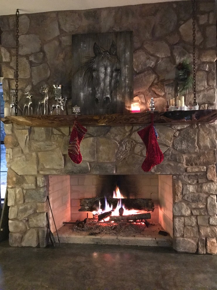 Mid-sized mountain style formal and open concept concrete floor and gray floor living room photo with a standard fireplace, a stone fireplace and no tv