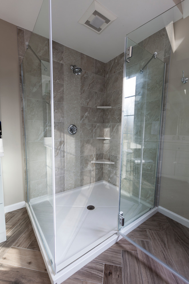 Inspiration for a mid-sized transitional master gray tile and porcelain tile porcelain tile and gray floor freestanding bathtub remodel in New York with flat-panel cabinets, gray cabinets, a two-piece toilet, gray walls, an undermount sink, quartz countertops and a hinged shower door