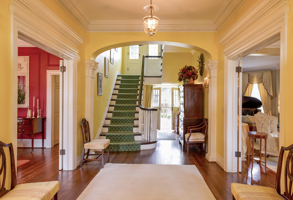 Photo of a large traditional entryway in Toronto with yellow walls and medium hardwood floors.
