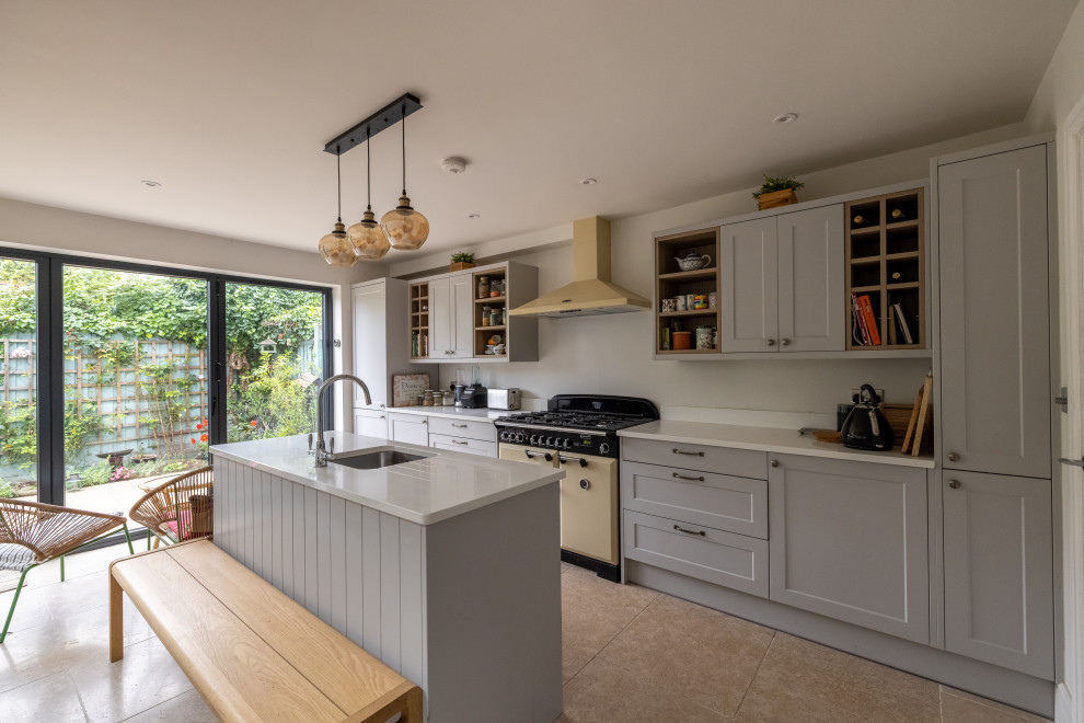 Foto på ett mellanstort funkis vit kök och matrum, med grå skåp, en köksö och beiget golv