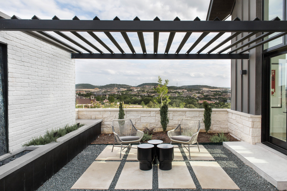Design ideas for a contemporary courtyard patio in Austin with gravel and a pergola.