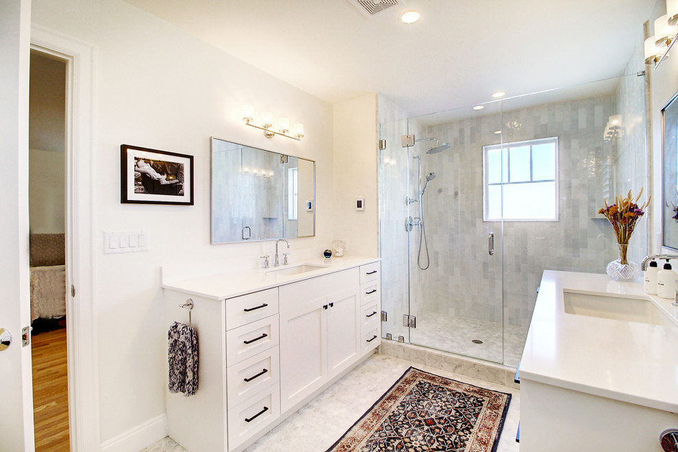 Photo of a medium sized scandinavian ensuite bathroom in Denver with recessed-panel cabinets, white cabinets, an alcove shower, a one-piece toilet, grey tiles, marble tiles, white walls, marble flooring, a submerged sink, solid surface worktops, white floors, a hinged door, white worktops, an enclosed toilet, double sinks and a built in vanity unit.