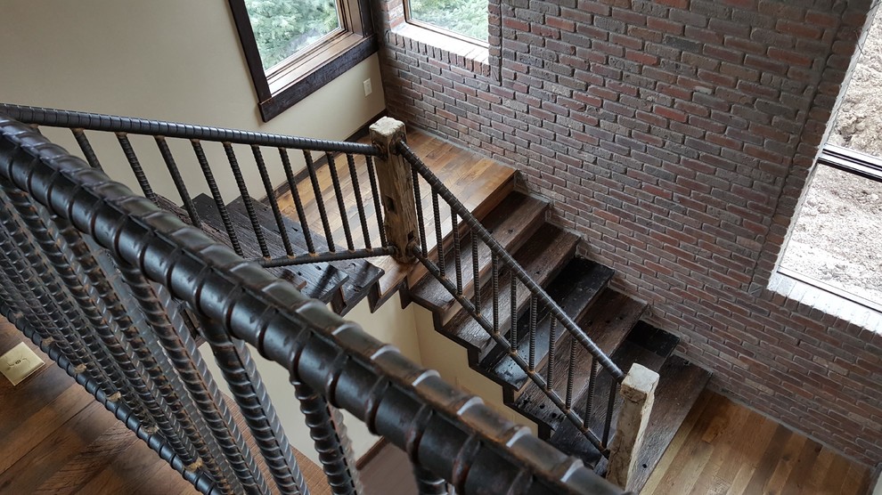 Design ideas for a large industrial wood l-shaped staircase in Other with wood risers and metal railing.